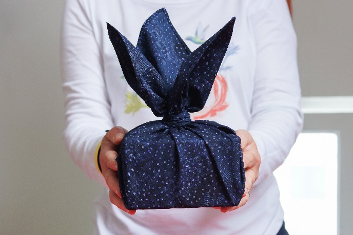 cadeau présenté emballé dans un furoshiki aux pointes relevées